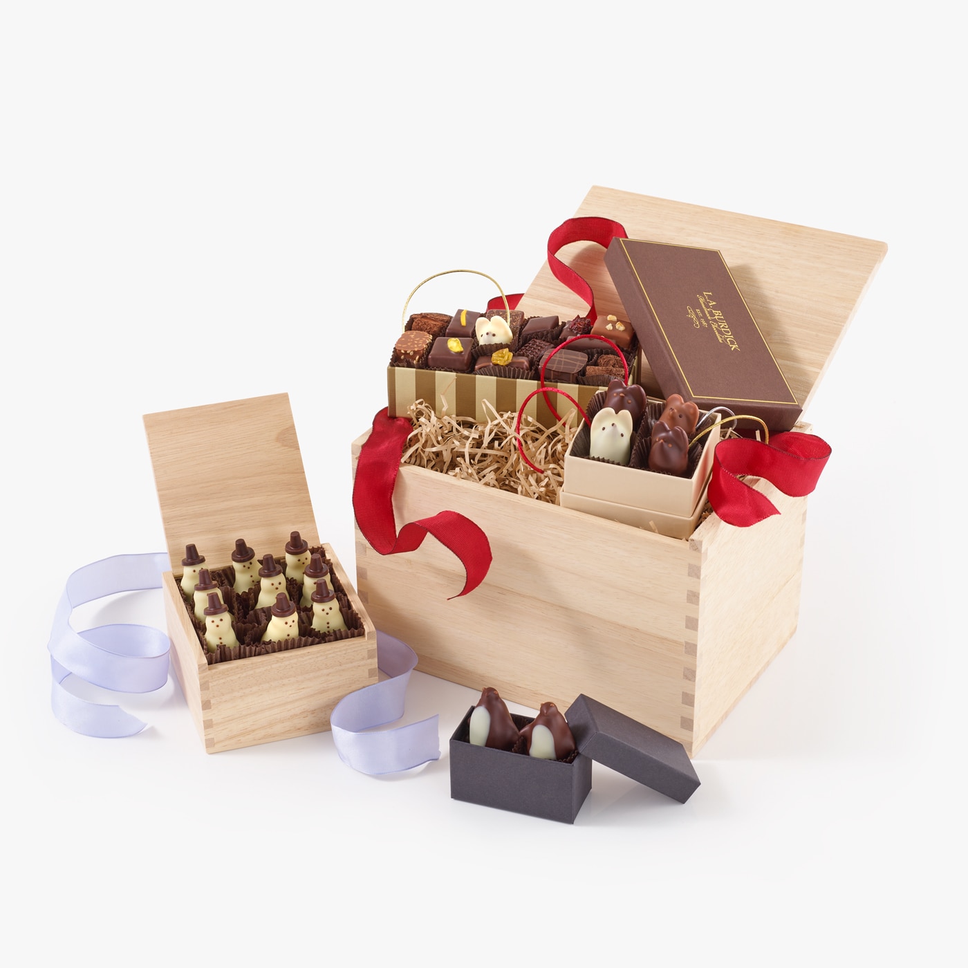 Large wooden crate filled with holiday chocolates including handmade snowmen and penguins.